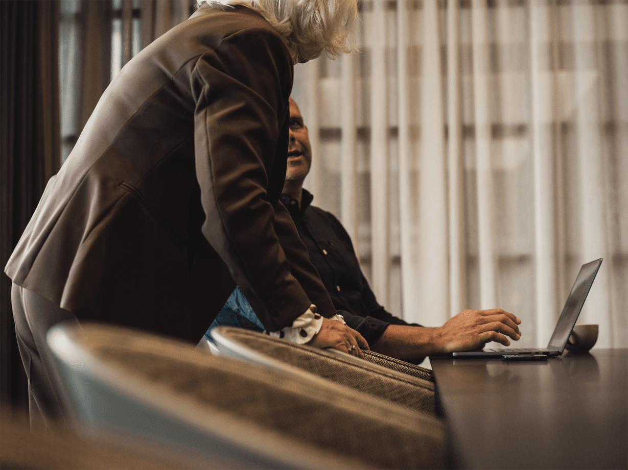 Man och kvinna pratar framför dator