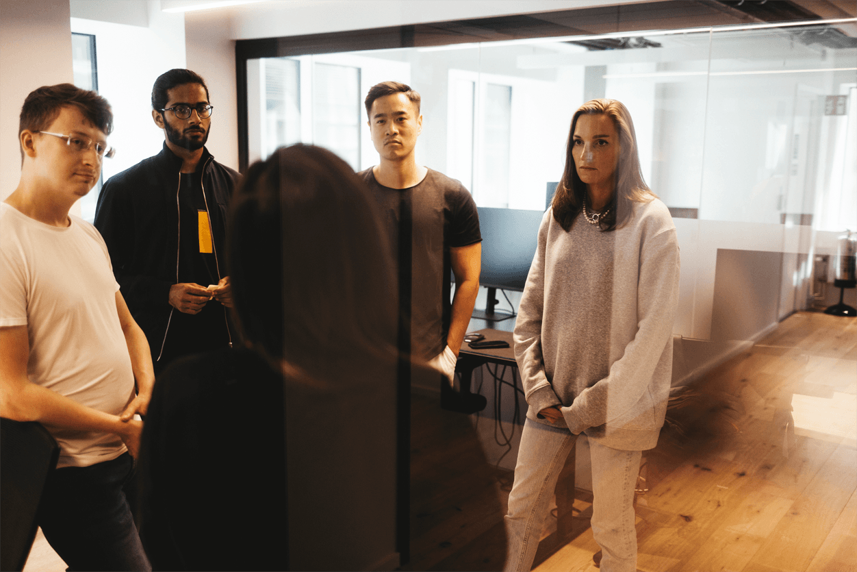 fem personer står och pratar på kontor