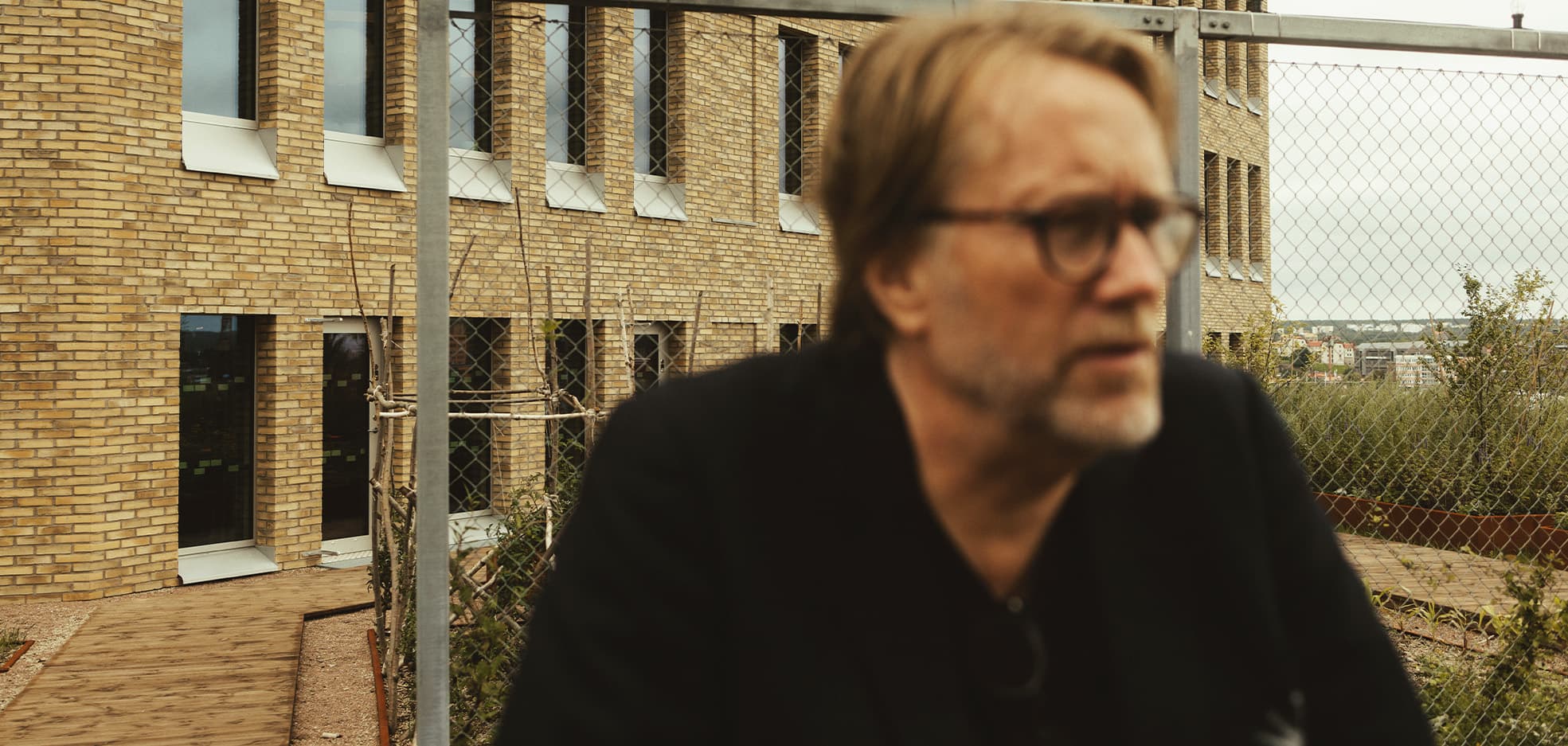 Man som står framför ett lägenhetshus