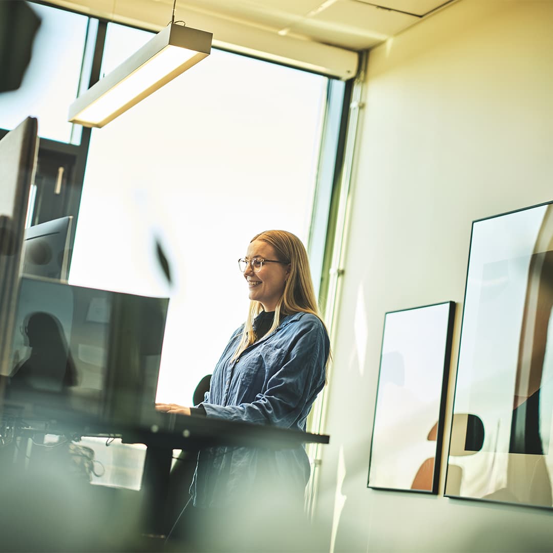 Tjej som arbetar i Fortnox bokföringsprogram vid en dator på sin kontorsplats.