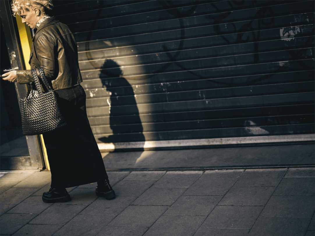 Kvinna som går utomhus och kollar i telefonen