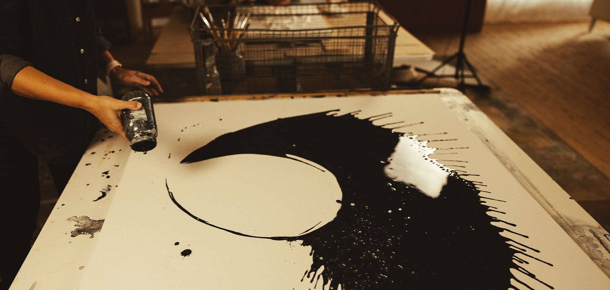 hand som målar en tavla med svart färg