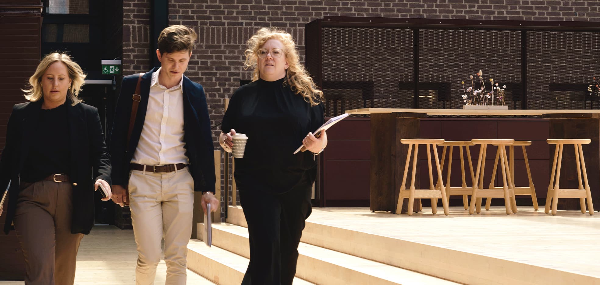 Tre personer går med varandra och pratar