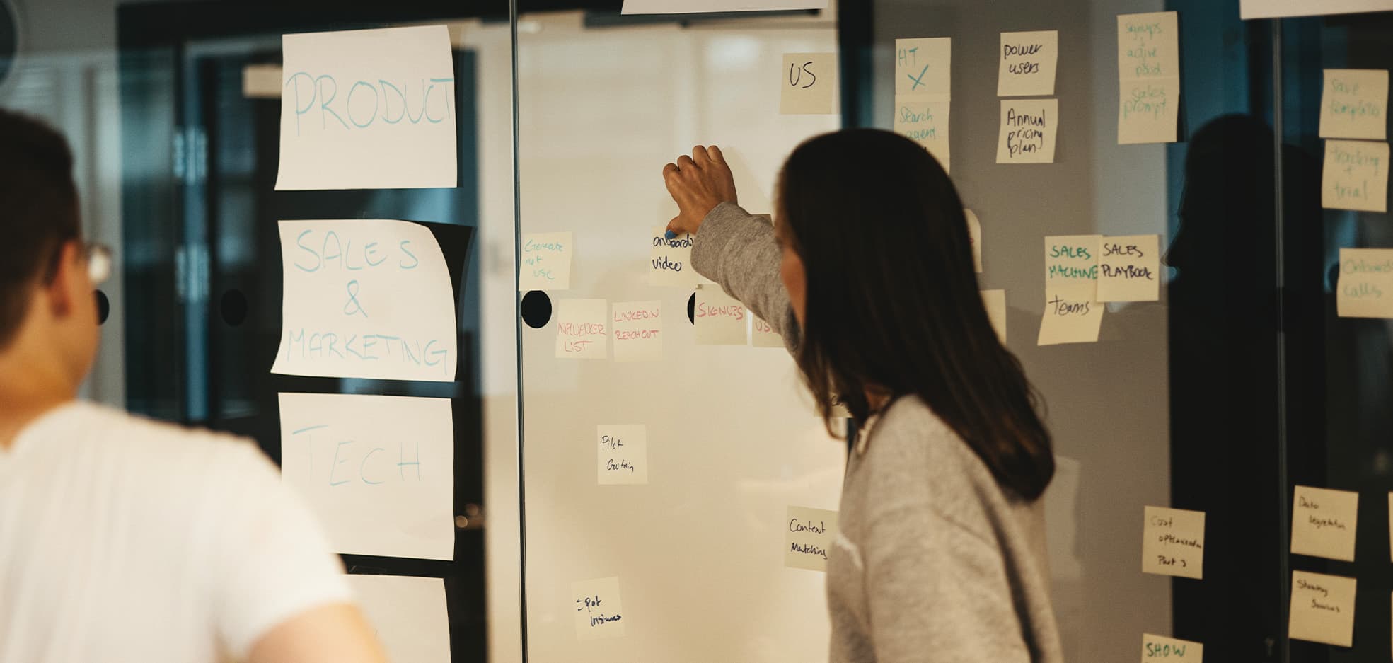 Två personer står och diskuterar med post-it