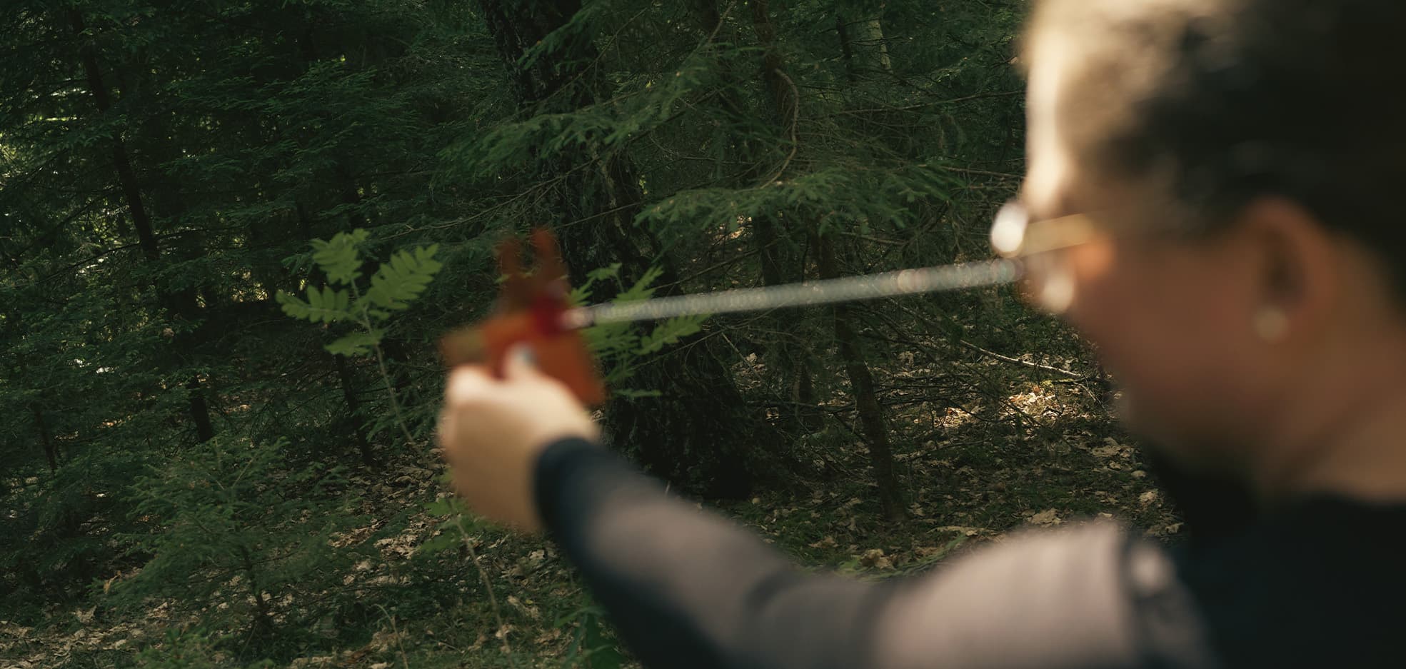 Kvinna ute i skogen med verktyg