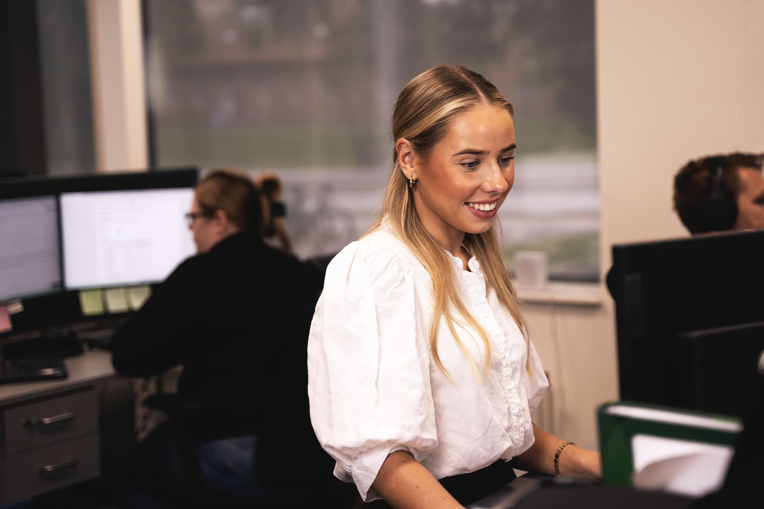 En kvinna står vid ett skrivbord